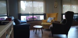 桑亨霍Hotel Cachada的客厅配有椅子和桌子,设有窗户