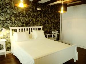 坎德莱达La Fonda de Candeleda的卧室配有白色的床和绿色的墙壁
