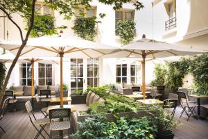 巴黎多布松酒店的一个带桌椅和遮阳伞的户外庭院。