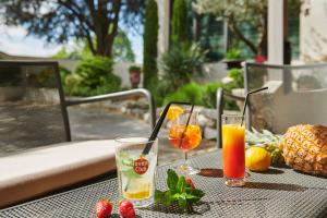 Margès夏龙桥餐厅酒店的一张桌子上放着两杯饮料和水果