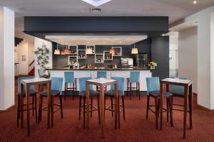 卡斯卡伊斯佩斯塔纳卡塞海洋与会议公寓酒店的厨房设有酒吧,配有蓝色的椅子和桌子