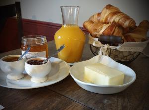 Teissières-lès-BoulièsL'Auberge de Teissières的一张桌子,上面放着两盘黄油和一篮面包
