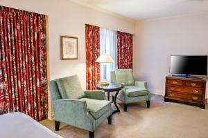 西雅图五月花公园酒店的酒店客房设有两把椅子、一张桌子和电视。
