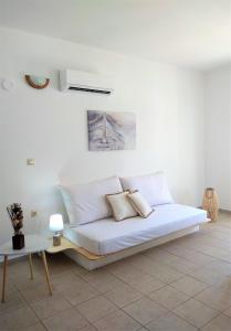 锡米Gompos Apartment - Cozy Apartment next to the sea - Amazing Sea View的客房内的一张带两个枕头的白色床