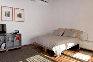 普利米里欧Suite in Masseria的一间白色卧室,配有床和电视