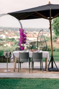 蒙蒂尼奥索Relais Montepepe Winery & Spa的露台的遮阳伞下的桌椅