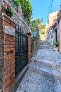 陶尔米纳Villa Valverde Apartments e B&B的一条带铁艺围栏和楼梯的小巷