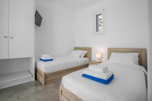 凯勒里瓦迪Mykonos4Islands Seaside Apartments的一间设有两张床和电视的房间