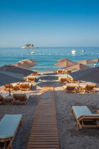 佩特罗瓦纳莫鲁Hotel Riva by Aycon的海滩上设有椅子和遮阳伞,还有大海