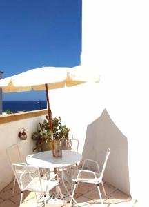 莱乌卡Villa La Floridiana - Sweet House的阳台配有桌椅和遮阳伞