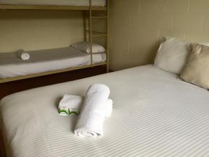 凯恩斯考拉海滩度假酒店凯恩斯店的一张带两张双层床的床铺,配有毛巾