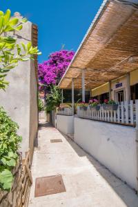 木洛希尼Hostel Flora的一条带白色围栏和紫色花卉的小巷