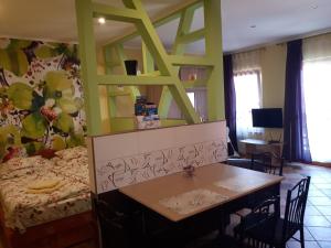 久洛Rozmaring Apartmanok的客房设有一张床和一张桌子及椅子