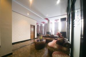 TelagaRedDoorz near TVRI Gorontalo的一间客厅,客厅配有沙发和椅子