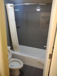 奥兰多奥兰多经济型汽车旅馆的一间带卫生间、浴缸和淋浴的浴室