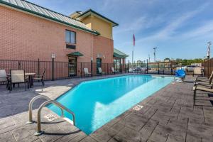 勒诺城勒诺城康福特茵酒店的一座带桌椅的游泳池位于酒店大楼旁