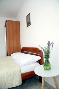 佩特罗瓦纳莫鲁阿尔杜拉公寓的一间卧室配有一张床和一张花瓶桌子