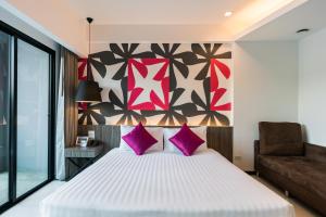 芭堤雅市中心Hotel J Residence Pattaya - SHA Extra Plus的卧室配有一张带粉红色枕头的大床