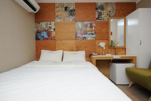 首尔明洞MIDO酒店的卧室配有一张白色大床和一张书桌