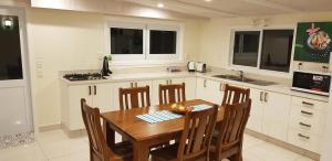 拉罗汤加Te Etu Villa 2的厨房配有木桌和一些椅子