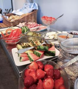 韦纳穆Hotell Apladalen i Värnamo的桌子上放有水果和蔬菜的盘子