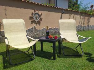 InfernettoVilla Vittorio的两把椅子和一张桌子及一瓶葡萄酒
