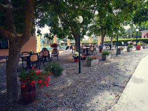 博纳索拉La Rossola Resort & Natura的公园里设有桌椅,树木和鲜花