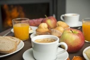 阿丰萨格拉达Hotel portico的一张桌子,上面放着咖啡、苹果和松饼