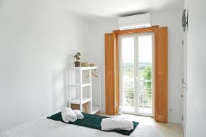 奥比多斯Mood Lodging - Caldas & Ocean的一间卧室设有一张床和一个大窗户