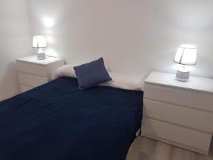 阿尔姆尼卡Ático en Almuñecar. Primera línea de playa con vistas espectaculares的一间卧室配有一张带2个床头柜和2盏灯的床。