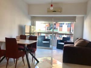 布宜诺斯艾利斯Apartamento Bulnes y Calle Corrientes的客厅配有桌椅和沙发