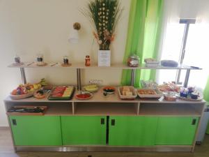 拉戈斯Sensations Guesthouse的展示柜,里面装有食品,有绿色的墙壁