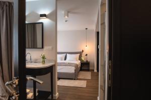 卡尔洛瓦茨Hotel Florian&Godler的一间卧室配有一张床,浴室设有水槽