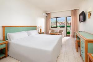 拉克鲁斯拉克鲁斯港特内里费阳光酒店的酒店客房设有一张白色大床和一个窗户。