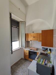 圣凯撒利亚温泉Miramare Vacanze Apartment的厨房配有木制橱柜、水槽和窗户。