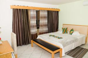 普拉亚LT Aparthotel的一间卧室配有一张带木制床头板和窗帘的床。