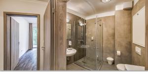 布达佩斯Nova City Apartments的一间带玻璃淋浴和水槽的浴室