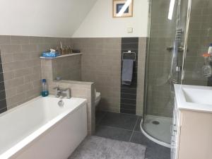 尚克林Martlets B&B的带浴缸、淋浴和盥洗盆的浴室
