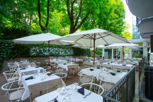 雷诺河畔卡萨莱基奥卡尔扎维切诺精品酒店的一间设有白色桌子和遮阳伞的餐厅