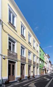 蓬塔德尔加达Pé Direito的街道上带阳台的黄色建筑