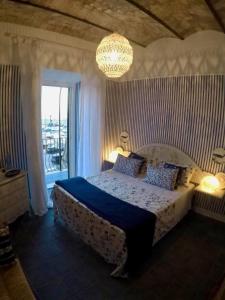 内图诺Le Stanze del Borgo的一间卧室配有一张床和一个吊灯