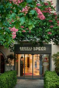 拉珀斯维尔-约纳斯皮尔索雷尔酒店的商店前有粉红色花的商店标志