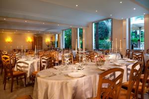 蒙特卡蒂尼泰尔梅帕玛E欧瑞恩特酒店的宴会厅配有桌椅和白色的桌布