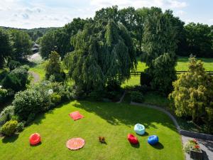 勒沃库森Landhotel Fettehenne的花园的空中景色,草地上摆放着遮阳伞