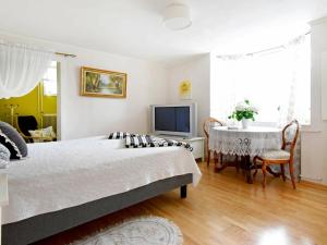 吕瑟希尔One-Bedroom Holiday home in Lysekil 11的一间卧室配有一张床、一张桌子和一台电视。