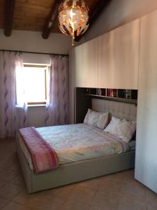 Meana di SusaCasa per vacanze in Meana di Susa的一间卧室配有一张带窗户和吊灯的床。
