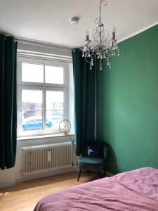 拜罗伊特Luna Estela的一间卧室设有绿色的墙壁、一张床和一个吊灯。
