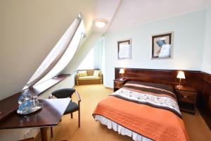 蒂黑Piramida Park Hotel & Wellness的一间卧室配有一张床、一张桌子和一把椅子