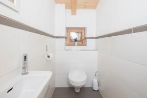 阿尔卑巴赫罗丝姆斯公寓的白色的浴室设有卫生间和水槽。