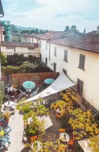 佛罗伦萨Ostello Tasso的享有带桌子和遮阳伞的天井的顶部景致。